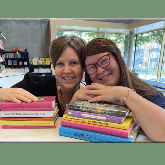 Mette og Signe med en bunke gode bøger